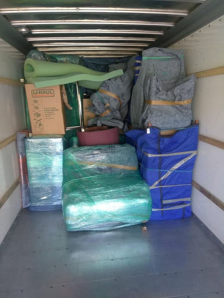 Sacramento moving crew loading tightly wrapped couches and furniture into a moving truck.